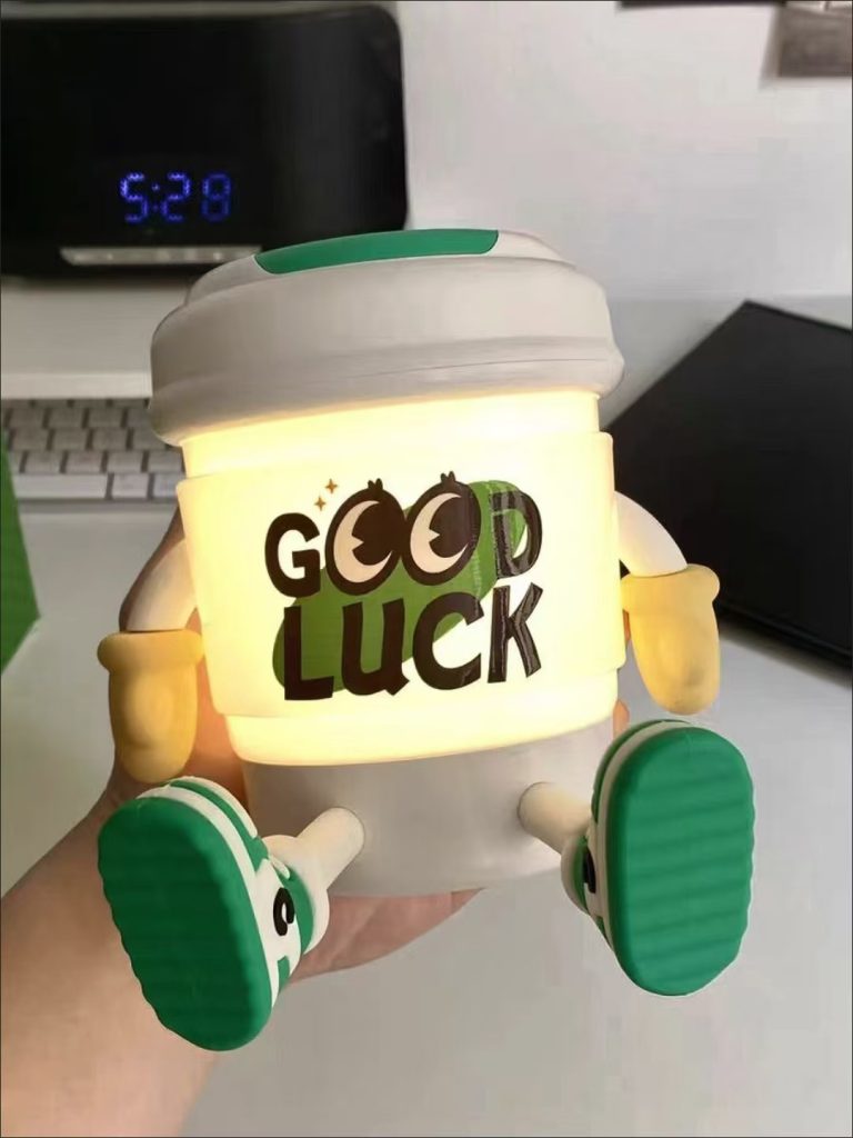 Creative Bluetooth speaker designed as a cartoon cup with graffiti, yellow arms, and green shoes, making it very lively.